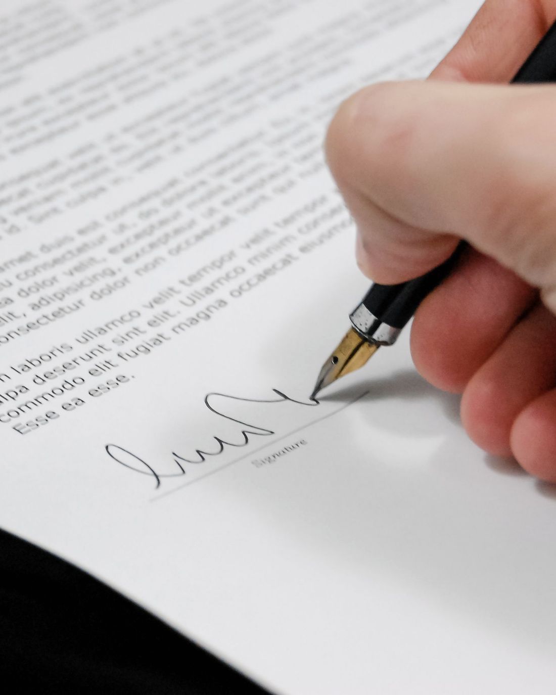 Contrato sobre un escritorio con una pluma fuente lista para firmar